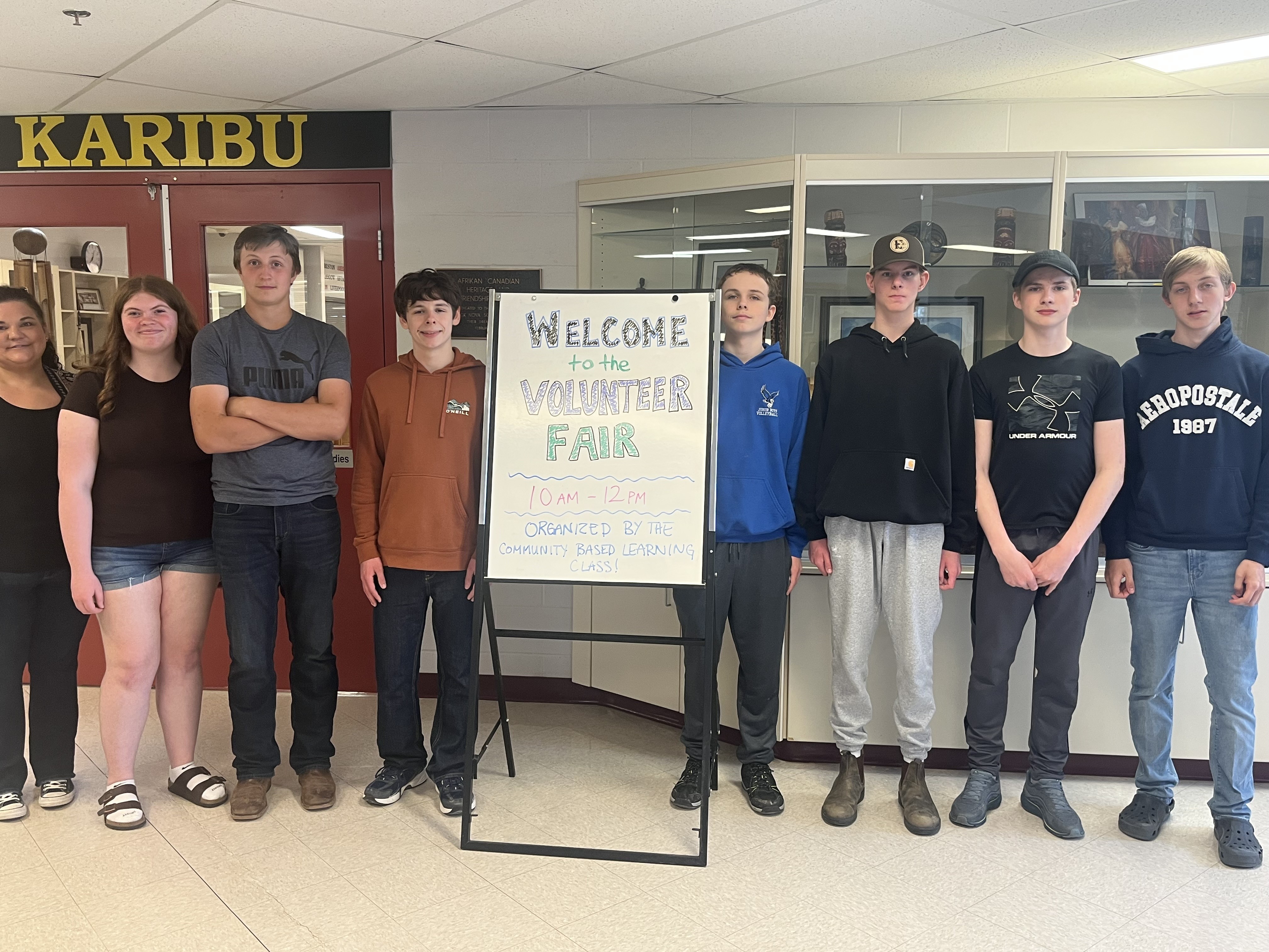 students standing in front of a sign that reads Welcome to the Volunteer Fair